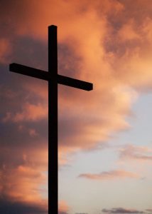 A solitary cross stands on a hill.