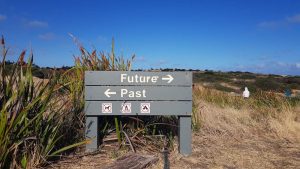 A sign with arrows pointing to the future and the past.